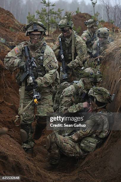 Members of the U.S. 173rd Airborne Brigade clear an enemy trench during the Iron Sword multinational military exercises on November 24, 2016 near...