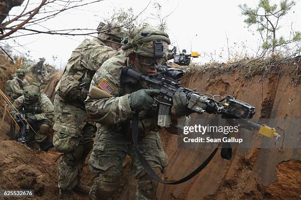 Members of the U.S. 173rd Airborne Brigade clear an enemy trench during the Iron Sword multinational military exercises on November 24, 2016 near...