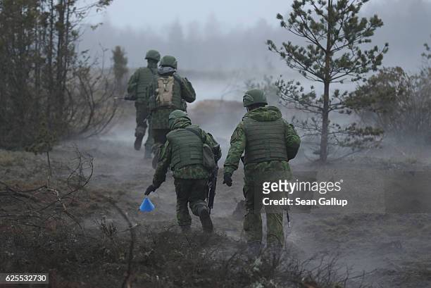 Lithuanian infantry soldiers move forward after firing a mine-clearing line charge while participating in the Iron Sword multinational military...