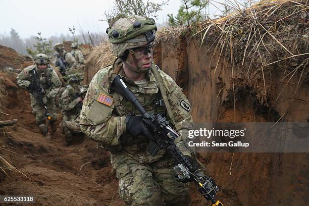 Members of the U.S. 173rd Airborne Brigade clear an enemy trench during a simulated attack while participating in the Iron Sword multinational...