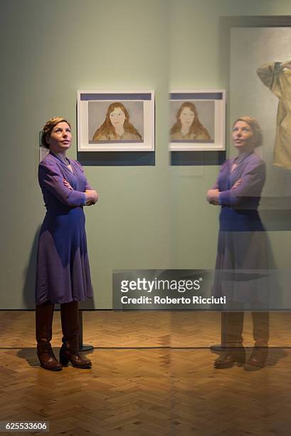 English artist Clara Drummond poses in front of her portrait 'Girl in a Liberty Dress' during the press launch of the exhibition 'BP Portrait Awards...