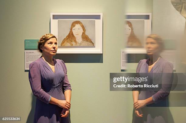 English artist Clara Drummond poses in front of her portrait 'Girl in a Liberty Dress' during the press launch of the exhibition 'BP Portrait Awards...