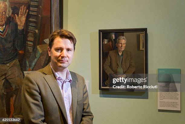 English artist Benjamin Sullivan poses in front of his portrait of 'Hugo' during the press launch of the exhibition 'BP Portrait Awards 2016' at the...