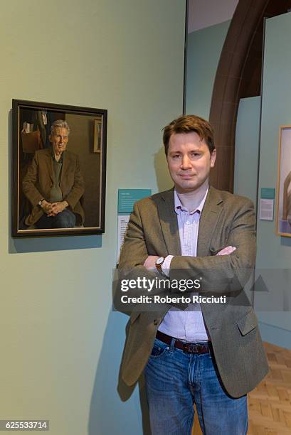 English artist Benjamin Sullivan poses in front of his portrait of 'Hugo' during the press launch of the exhibition 'BP Portrait Awards 2016' at the...