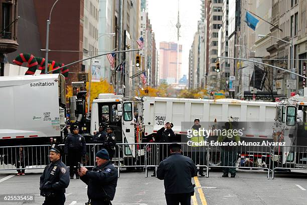 Officers stand guard next to trucks as people arrive to watch the 90th Macy's Annual Thanksgiving Day Parade on November 24, 2016 in New York City....