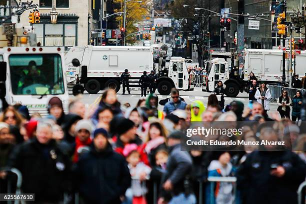 Officers stand guard next to trucks as people watch the 90th Macy's Annual Thanksgiving Day Parade on November 24, 2016 in New York City. Security...