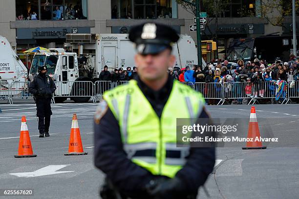 Officers stand guard next to trucks as people watch the 90th Macy's Annual Thanksgiving Day Parade on November 24, 2016 in New York City. Security...