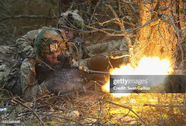 Members of the U.S. 173rd Airborne Brigade fire blanks from a machine gun during a simulated attack during the Iron Sword multinational military...
