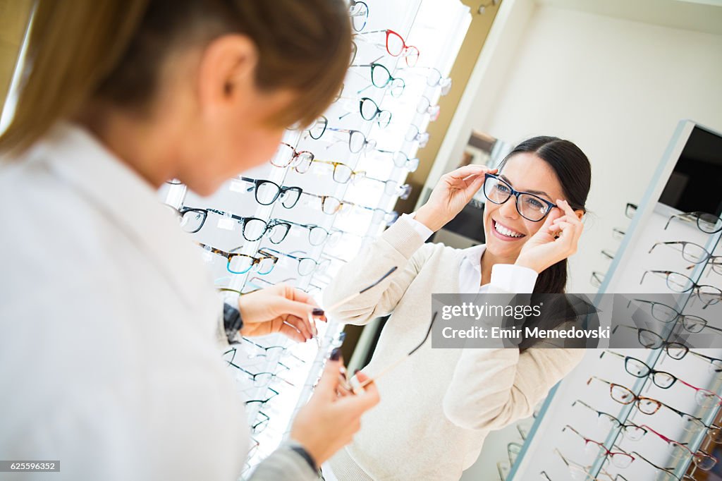Woman trying on eyeglasses in optical shop