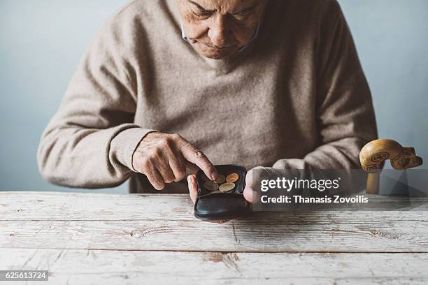 an elderly man look for some money from his wallet - povertà foto e immagini stock