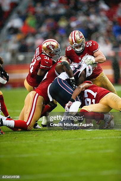 Gerald Hodges, Nick Bellore, Quinton Dial and Keith Reaser of the San Francisco 49ers team up to tackle Dion Lewis of the New England Patriots during...