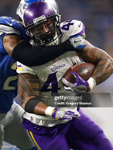 Glover Quin of the Detroit Lions tackles Matt Asiata of the Minnesota Vikings during second half action at Ford Field on November 24, 2016 in...