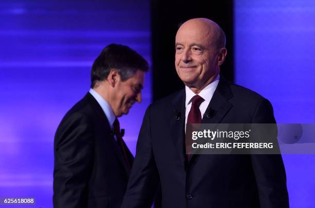 The two finalists in France's conservative presidential primary, Francois Fillon and Alain Juppe, leave after posing for photographs prior to taking...