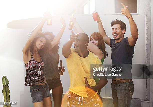 group of friends partying on rooftop - lise gagne stock pictures, royalty-free photos & images