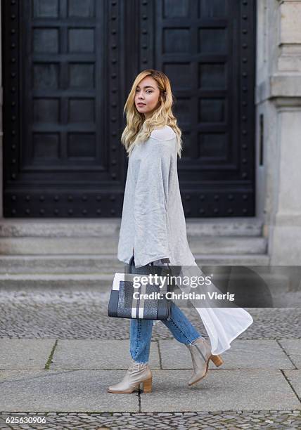 Jessi Quednau wearing light grey Buffalo boots, blue Levis denim jeans, grey poncho Zara, white blouse Zara, a grey white Steve Madden bag on...