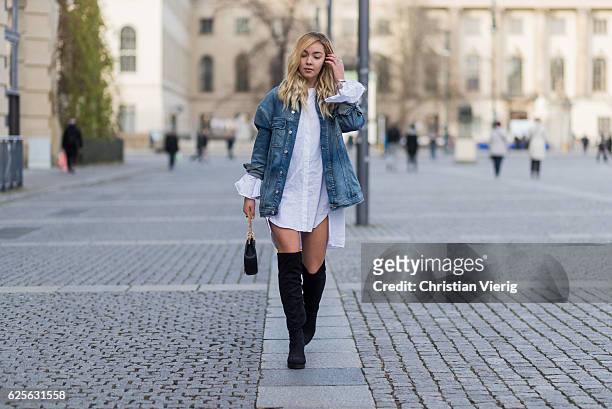 Jessi Quednau wearing black heeled overknees Asos, a white dress with long wide sleeves Storets, a blue denim jacket with print on the back Mavi, a...