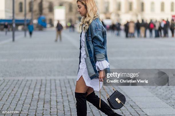 Jessi Quednau wearing black heeled overknees Asos, a white dress with long wide sleeves Storets, a blue denim jacket with print on the back Mavi, a...