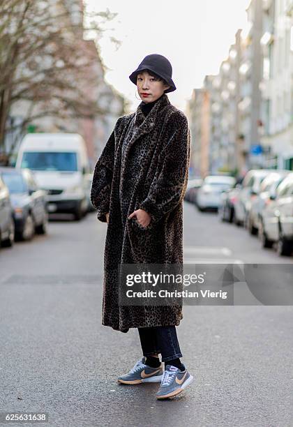 Minju Kim wearing leopard print coat, bucket hat, black denim jeans, Nike sneakers on November 24, 2016 in Berlin, Germany.