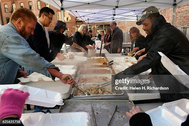 Volunteer TJ Cole, right, and Bryan Blackmon, left, prepare Thanksgiving day lunches at The Squeaky Bean to be delivered to the homeless shelters,...