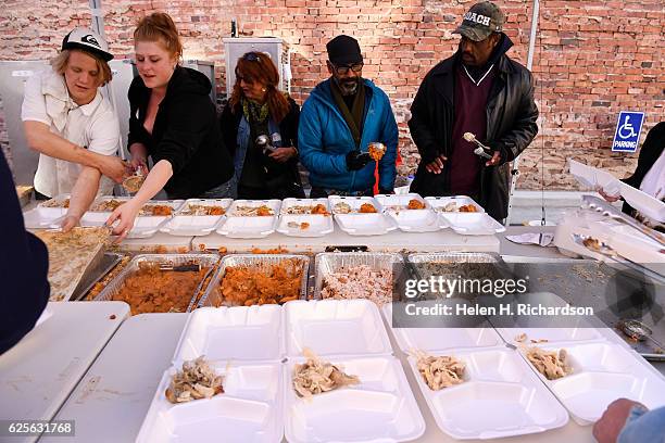 Volunteer TJ Cole, right, and others prepare Thanksgiving day lunches at The Squeaky Bean to be delivered to the homeless shelters, senior centers...