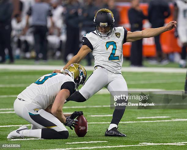 Brad Nortman of the Jacksonville Jaguars holds the football for kicker Jason Myers of the Jacksonville Jaguars during an NFL game against the Detroit...