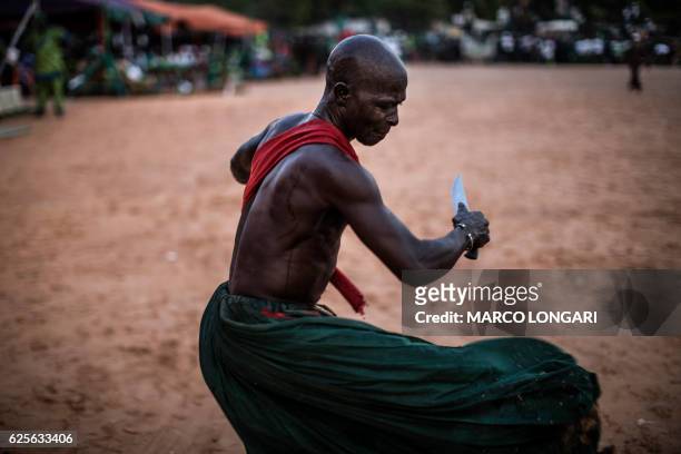 Performer from the Joles ethnic group in Gambia prepares to perform with sharp blades which they say will demonstrate the magic powers of a spiritual...