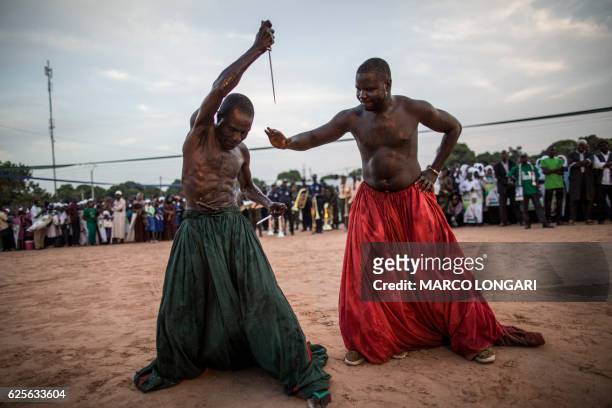 Performers from the Joles ethnic group in Gambia prepare to perform with sharp blades which they say will demonstrate the magic powers of a spiritual...