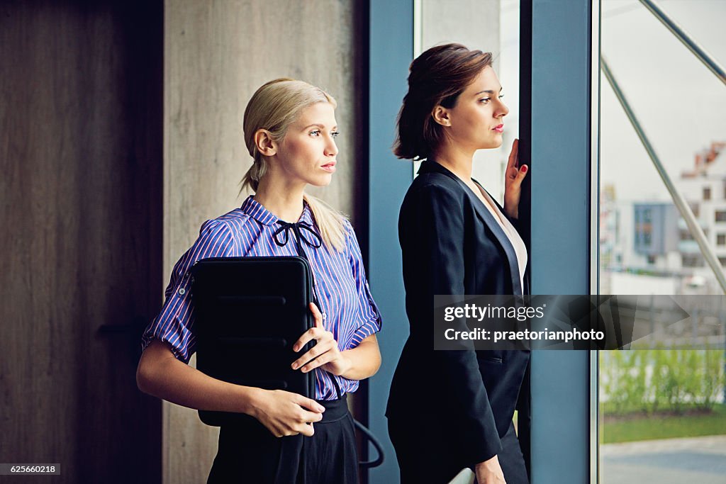 Porträt von Geschäftsfrauen, die am Fenster stehen