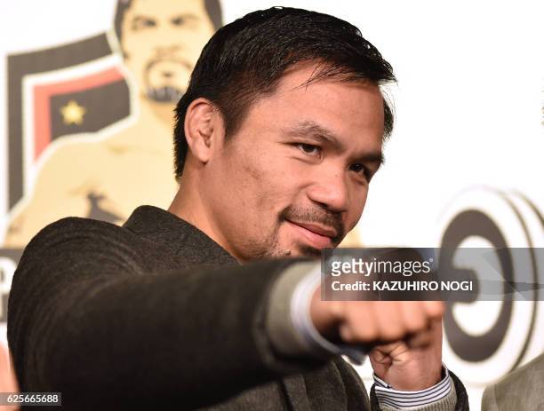 Welterweight world champion Manny Pacquiao poses for the media following a press conference at his boxing gym in Tokyo on November 25, 2016. - WBO...
