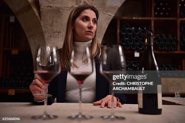 Virginie Routis, head sommelier at the Elysee Palace, samples wine in the Elysee wine cellar in Paris on November 18, 2016. A customer of a great...