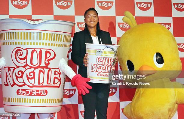 Japanese tennis player Naomi Osaka, the 2016 WTA Newcomer of the Year, poses for a photo at a press conference in Tokyo on Nov. 25 after signing a...