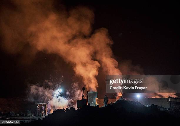 Chinese labourer works as smoke and steam rises from an unauthorized steel factory on November 3, 2016 in Inner Mongolia, China. To meet China's...