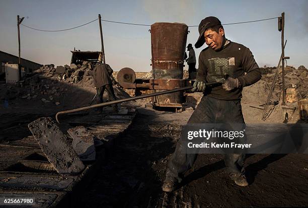 Chinese labourer works next to the furnace at an unauthorized steel factory on November 3, 2016 in Inner Mongolia, China. To meet China's targets to...