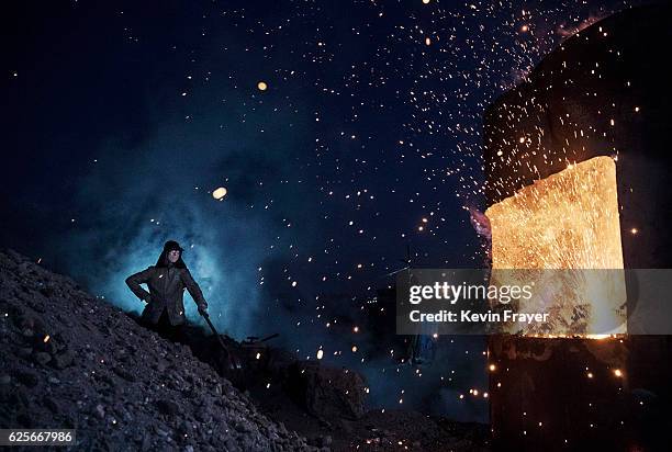 Chinese labourer stands near a furnace as he works at an unauthorized steel factory on November 3, 2016 in Inner Mongolia, China. To meet China's...