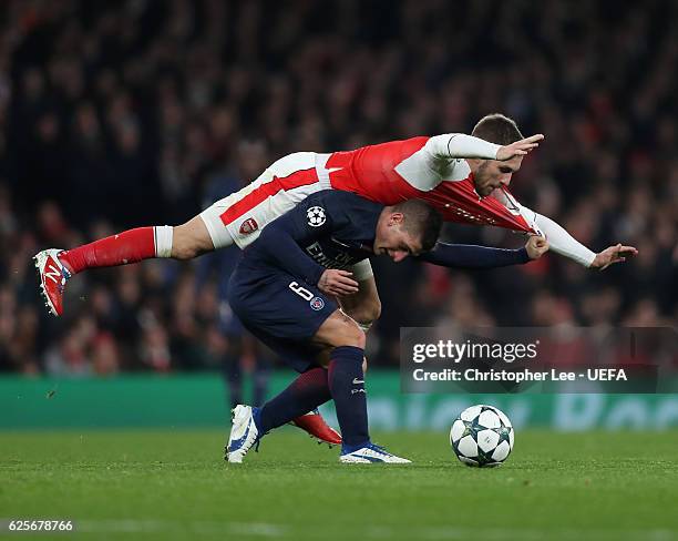 Marco Verratti of PSG is below Aaron Ramsey of Arsenal as they battle for the ball during the UEFA Champions League match between Arsenal FC and...