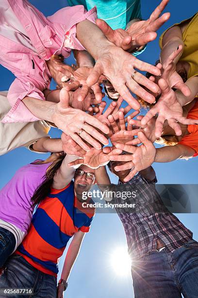 below view of large group of people reaching towards camera. - woman reaching hands towards camera stock pictures, royalty-free photos & images