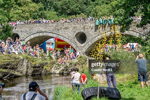 river duck race with crowds cheering them on - village fete stock pictures, royalty-free photos & images