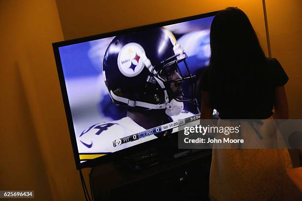 Child of Guatemalan immigrants watches football at a Thanksgiving celebration on November 24, 2016 in Stamford, Connecticut. Family and friends, some...