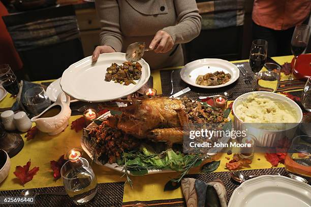 Guatemalan immigrant serves stuffing from the Thanksgiving turkey on November 24, 2016 in Stamford, Connecticut. Family and friends, some of them...