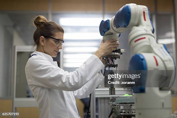 mujeres ingenieras trabajando con brazo robótico - cam fotografías e imágenes de stock