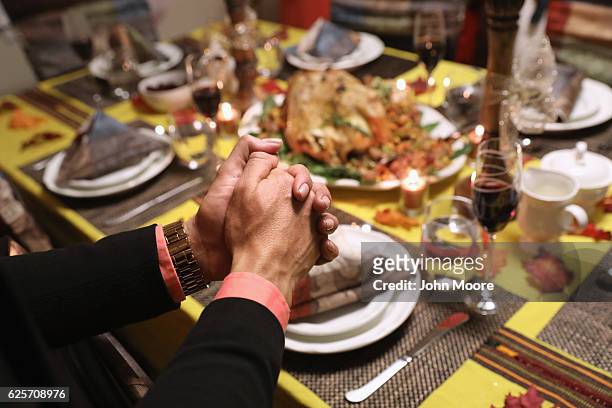 Central American immigrants and their families pray before Thanksgiving dinner on November 24, 2016 in Stamford, Connecticut. Family and friends,...