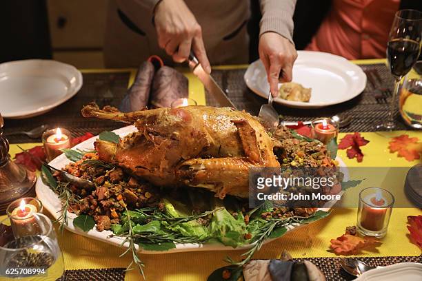 Guatemalan immigrant carves the Thanksgiving turkey on November 24, 2016 in Stamford, Connecticut. Family and friends, some of them U.S. Citizens,...