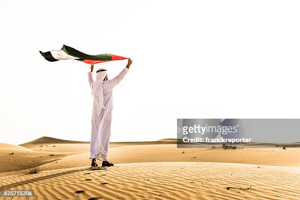 scheich schwenkt die vae flagge für nationaltag - vereinigte arabische emirate stock-fotos und bilder