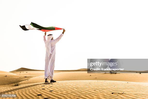 sheik waving the uae flag for national day - emirate stockfoto's en -beelden