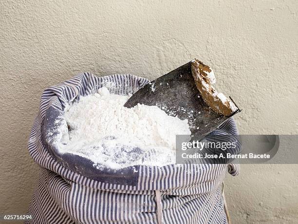 sack of flour of ancient fabric of cotton and a metallic spoon - flour bag stockfoto's en -beelden