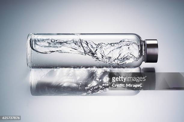 water wave in glass bottle - mineral water stock pictures, royalty-free photos & images