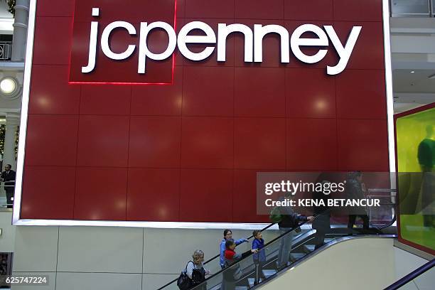 People exit from JCPenny store at Herald Square on November 25 in New York. Fresh from their Thanksgiving festivities, millions of Americans flock to...