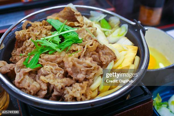 sukiyaki served in hot pot with raw egg - sukiyaki stock-fotos und bilder