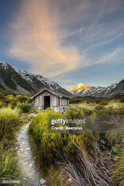 shelter at hooker valley track with mount cook as background at aoraki mount cook national park. - mt cook stock-fotos und bilder