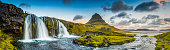 Mountain waterfalls below rocky peaks panorama at sunrise Kirkjufell Iceland